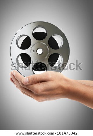 Man hand holding object ( Cinema film roll and strip ) High resolution