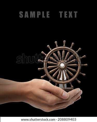 Man hand holding object ( wooden steering-wheel ) isolated on black background. High resolution