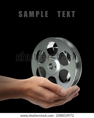 Cinema film roll and strip. Man hand holding object  isolated on black background. High resolution