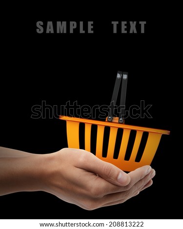 orange plastic shopping basket. Man hand holding object isolated on black background. High resolution
