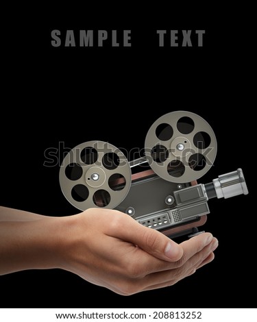 cinema projector old-fashioned. Man hand holding object isolated on black background. High resolution