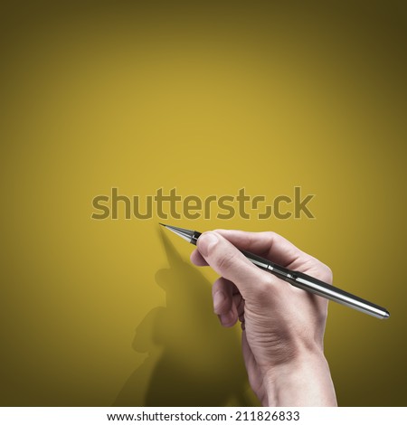 male hand with pen isolated on orange background