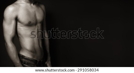 portrait of a sexy muscular shirtless man against neutral black and white
