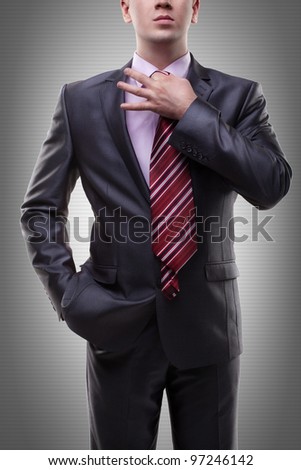 Businessman in a suit straightens his tie.