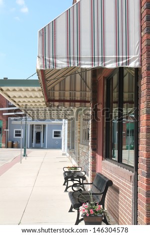Small town America sidewalk scene showing storefronts.