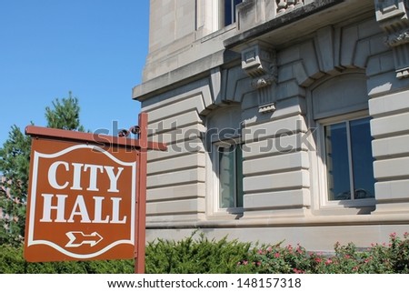 City Hall Sign in front of a city hall building.