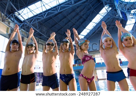 happy children kids group at swimming pool class learning to swim
