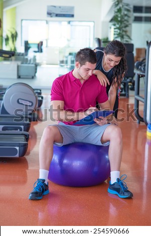 Young women with her personal fitness trainer in the gym