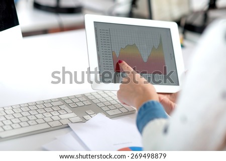 Female hand pointing a finger on a tablet