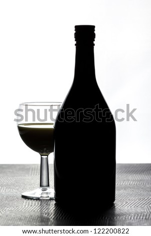 Glass next to a bottle backlit with bright light/Glass next to a bottle/Alcohol drink