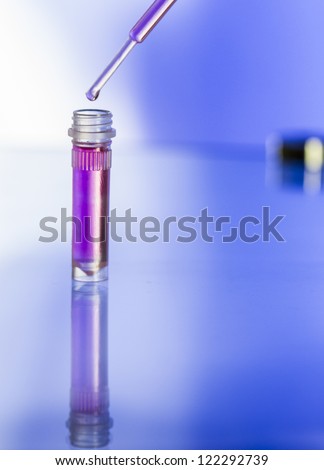 Test tube with pink liquid and a pippet/Lab sample and pipette/Laboratory