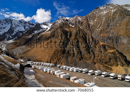 Lots of white caravans in front of the Pyrenees mountains in France