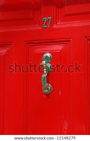 View of a metallic door knocker in a red door in Dublin, Ireland