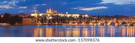 Pretty night time illuminations of Prague Castle, Charles Bridge and St Vitus Cathedral reflected in the Vltava river running through the heart of the city of Prague in the Czech Republic.