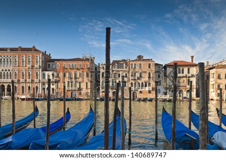 Traditional 16th century villas, blue skies and gondolas along the Grand Canal in Venice.