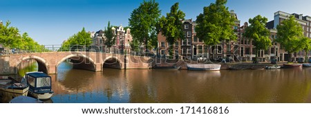 Pretty dutch doll houses and house boats reflected in the tranquil canals of Amsterdam, Holland.