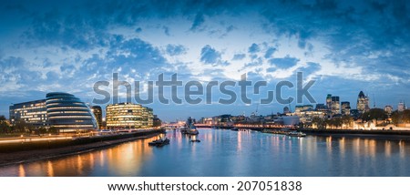 Pretty nighttime illuminations of the River Thames, many sights visible including London City Hall, HMS Belfast, Tower of London and the cities financial district.