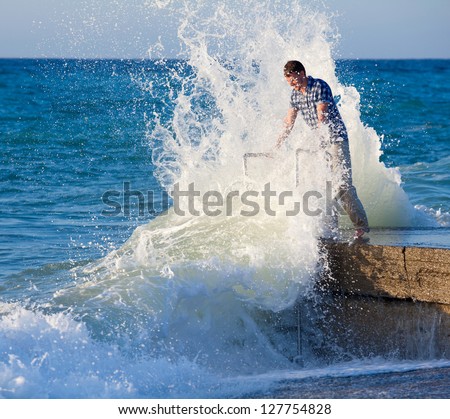 Man on the pier and big waves