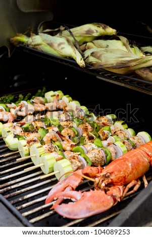 Salmon Skewers, Lobster and cornstalks are on the barbecue.
