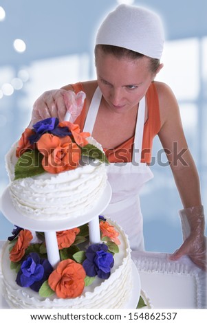Woman with white bandanna giving to a wedding cake latest small retouches