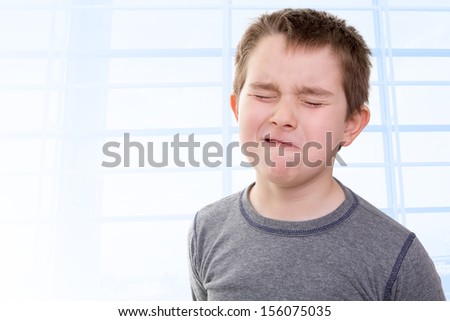 Eight years old kid feeling the pain that shows with his facial expression