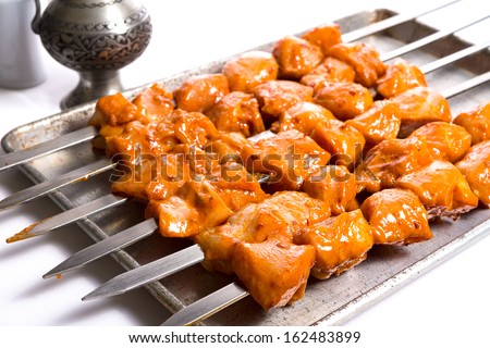 Well seasoned chicken skewers are waiting on aluminum tray, ready to go on to the grill and cook
