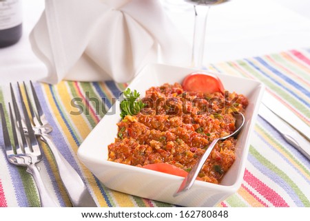 Meze, diced tomatoes with parsley, walnuts and hot red peppers seasoned with lemon juice served on a colorful  place mat