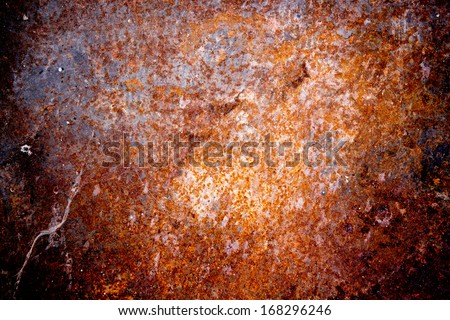 Grungy old rusting metal surface with pitted flaking blue paint and red ferric oxides or corroded rust caused by moisture and weathering, background texture