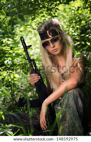 Beautiful young woman holding an automatic assault rifle