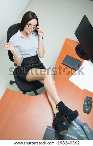 beautiful business woman threw her legs on the table. smiling