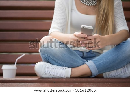 smart professional woman reading using phone. Female businesswoman reading news or texting sms on smartphone while drinking coffee on break from work.