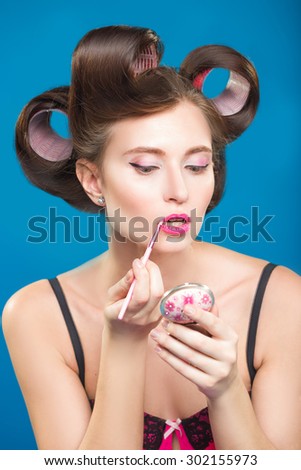 Sexy young pin-up girl doing make-up