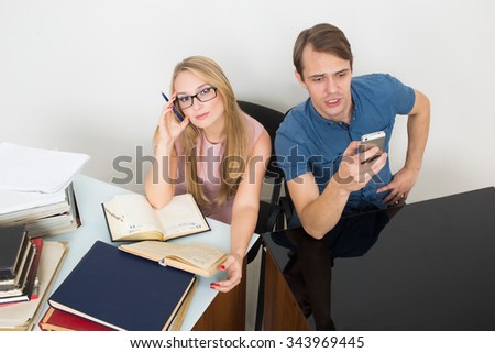library. woman looking for information in books. The man speaks on the phone