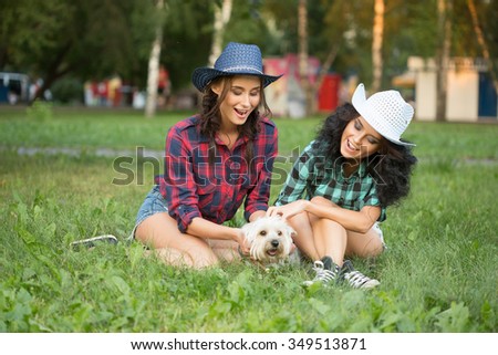 Two girls walking with his dog. cowboy hat and plaid shirt