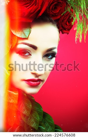 Beautiful woman with flowers and leafs in her hair. She looks psychedelic.