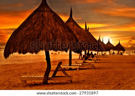 Beach beds and umbrellas at colorful dawn