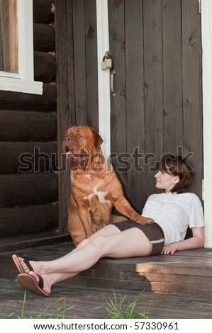 Big Guard Dog and her master young woman are sitting at the doorstep