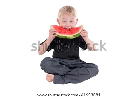 Little boy sitting on the floor taking a big bite from a watermelon