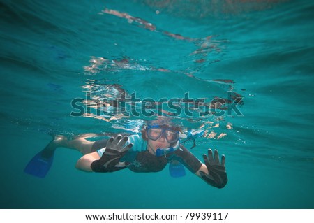 Woman snorkeling in the open ocean looking curiously at something