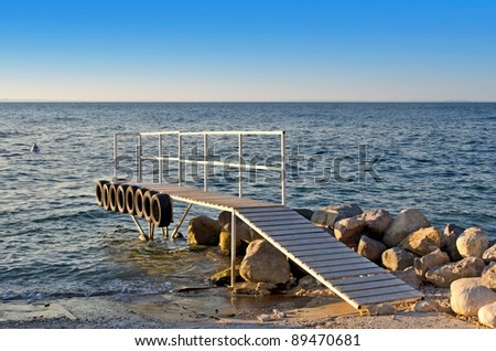 Wooden pier with tires on its side