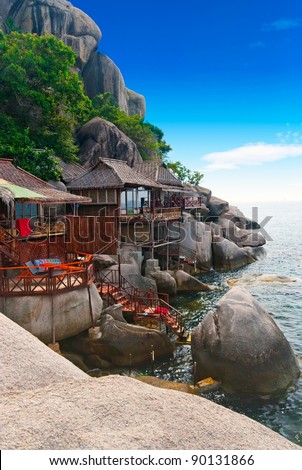 Tropical wooden villas on the rocks of a bay