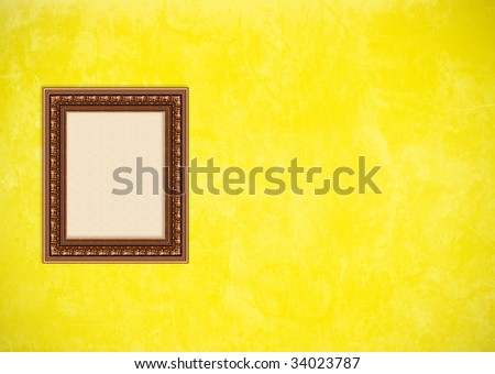 Empty baroque picture frame with copyspace on a yellow grunge stucco wall