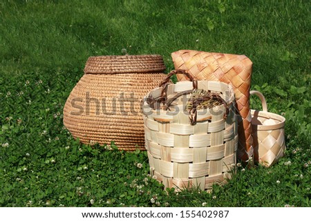 Wicker baskets and boxes made of birch bark on the green grass