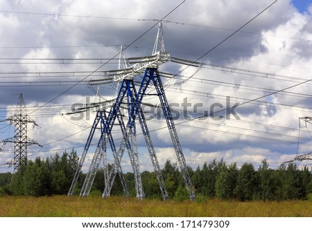 Metal poles with electric wires on a summer landscapes background