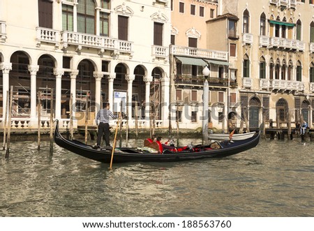 VENICE,ITALY-MARCH 30-The gondolier floats on a gondola with tourists in March 30,2014  in Venice
