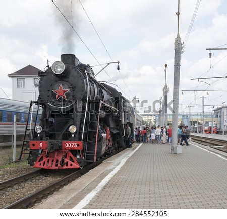 RUSSIA; ROSTOV-ON-DON - MAY 31 - Passengers sit in a car, driven by a steam locomotive. Mechanics lubricated steam locomotive on May 31,2015 in Rostov-on-Don