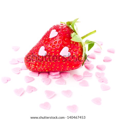 Funny ripe strawberry isolated on white background, decorated with sweet hearts, closeup
