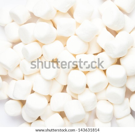 A pile of small white puffy marshmallows on white background. Close up