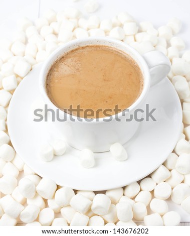 Closeup of cup of hot cocoa with small marshmallows resting on background