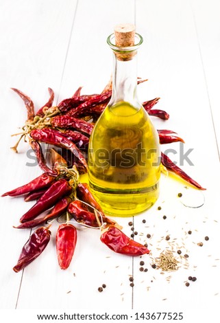 Olive oil bottle and Red hot chili pepper on white
